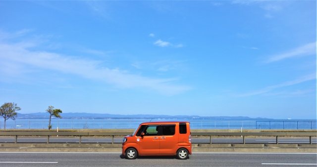走るオレンジ色の軽自動車